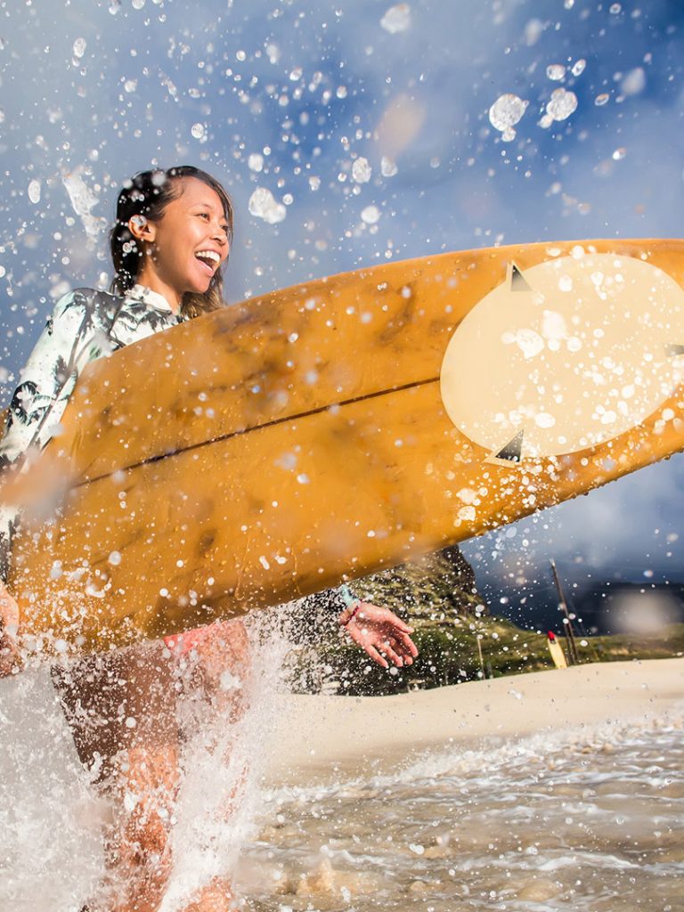 A girl ready to surf and to use Poncho microfiber PIMPUP